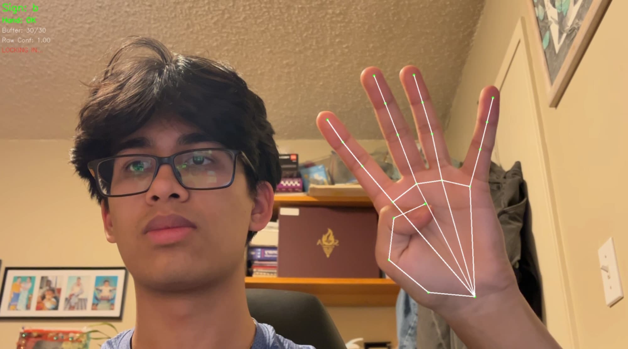 webcam view of a raised hand with mediapipe landmarks drawn over it and the predicted sign and confidence in the corner