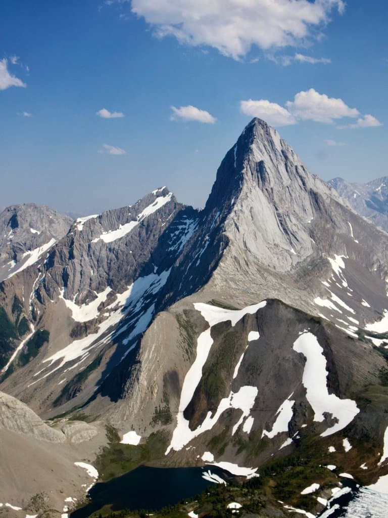 mount smutwood's pointed grey limestone peak above snowy alpine lakes